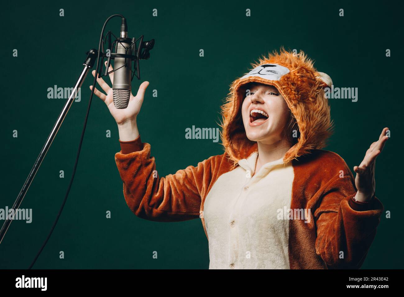 La donna si prepara e un materiale prima della registrazione vocale. Sala insonorizzata per la registrazione vocale professionale. L'artista della voce lavora con il materiale befor Foto Stock