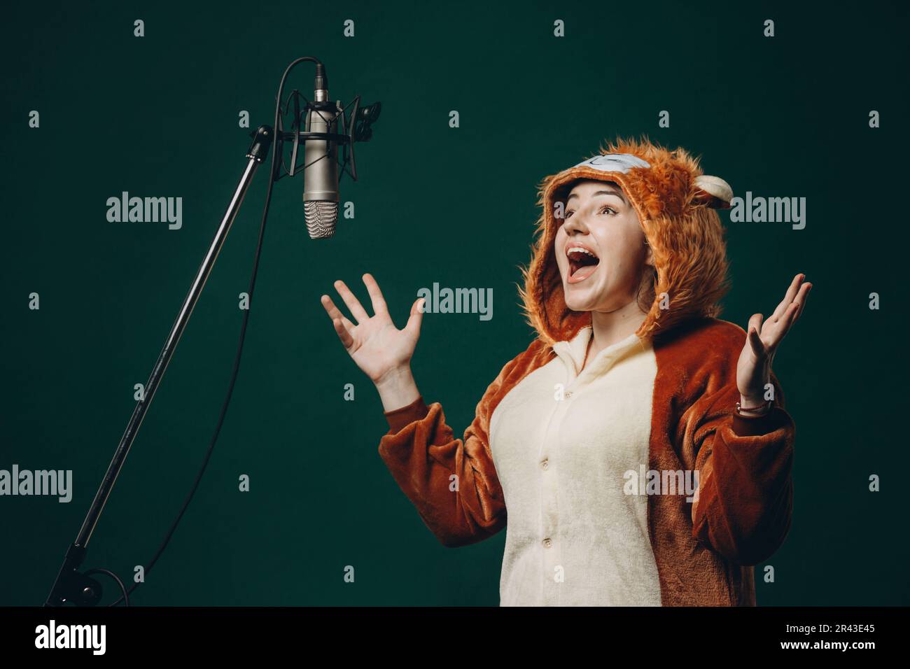 La donna si prepara e un materiale prima della registrazione vocale. Sala insonorizzata per la registrazione vocale professionale. L'artista della voce lavora con il materiale befor Foto Stock