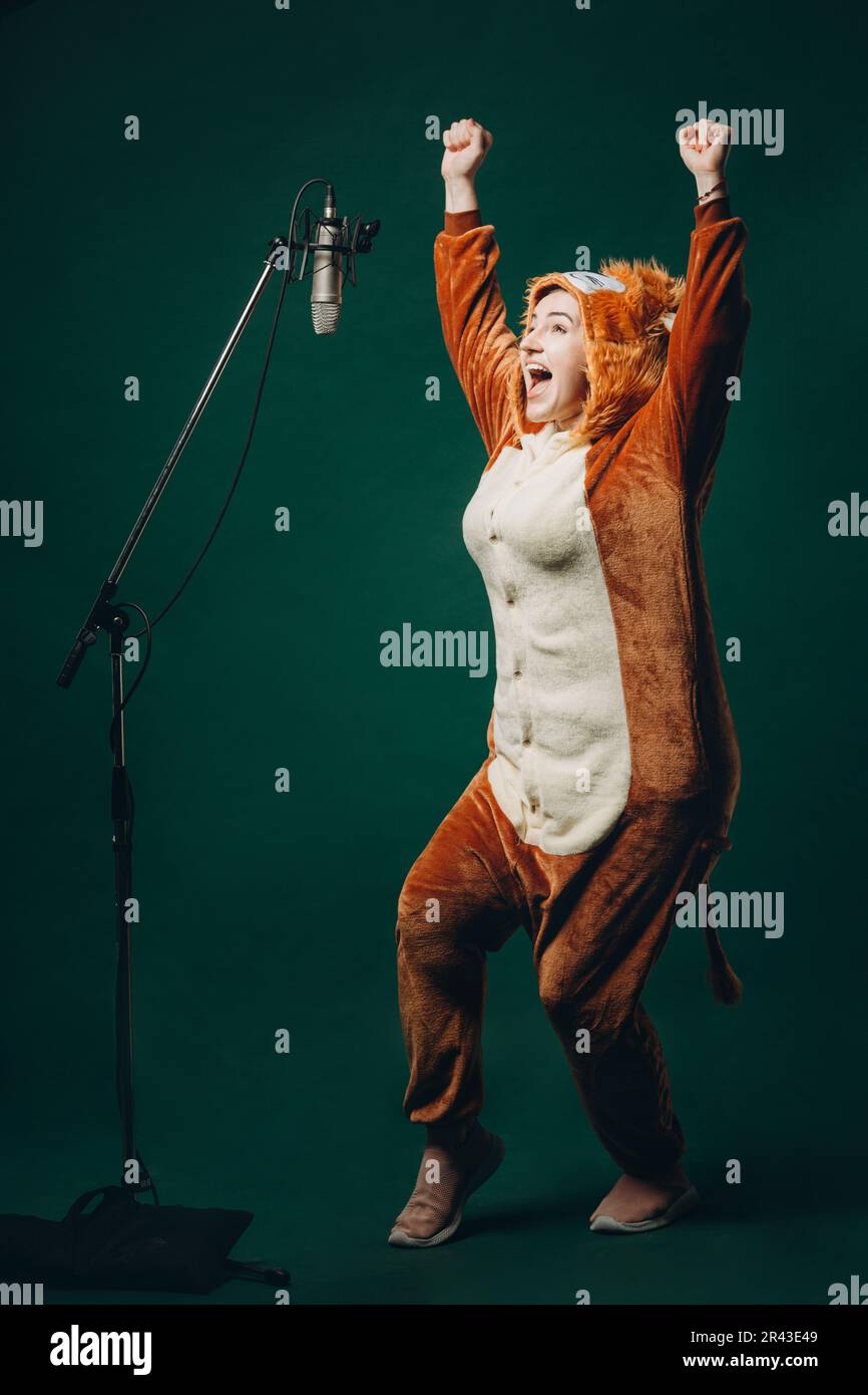 La donna si prepara e un materiale prima della registrazione vocale. Sala insonorizzata per la registrazione vocale professionale. L'artista della voce lavora con il materiale befor Foto Stock