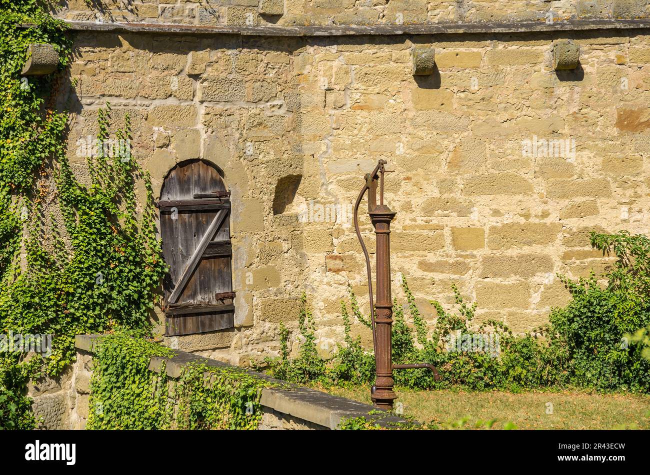 Castello di Ravensburg a Kraichgau vicino Sulzfeld, regione di Heilbronn, Baden-Württemberg, Germania, pompa d'acqua antiquata nel cortile esterno. Foto Stock