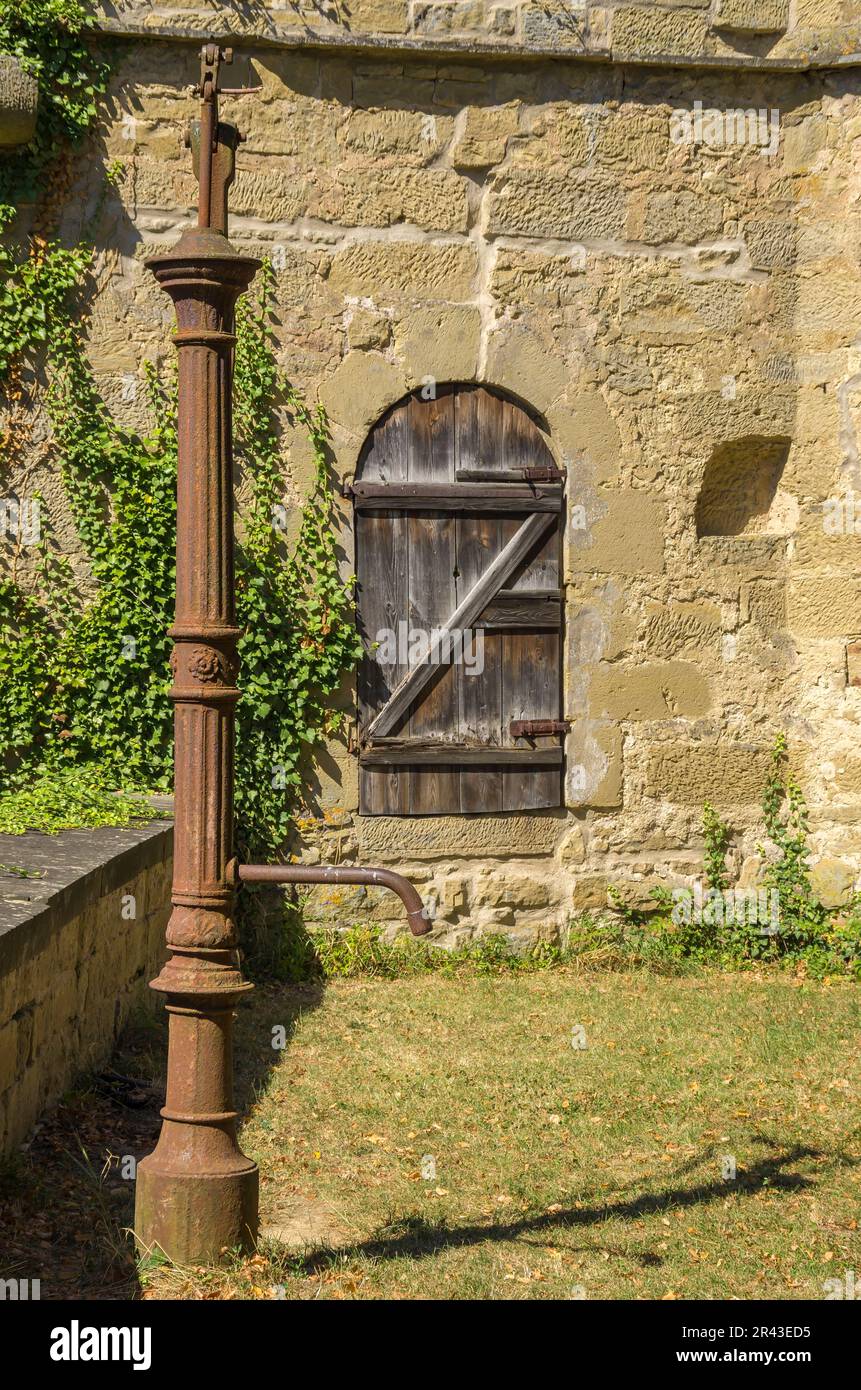 Castello di Ravensburg a Kraichgau vicino Sulzfeld, regione di Heilbronn, Baden-Württemberg, Germania, pompa d'acqua antiquata nel cortile esterno. Foto Stock