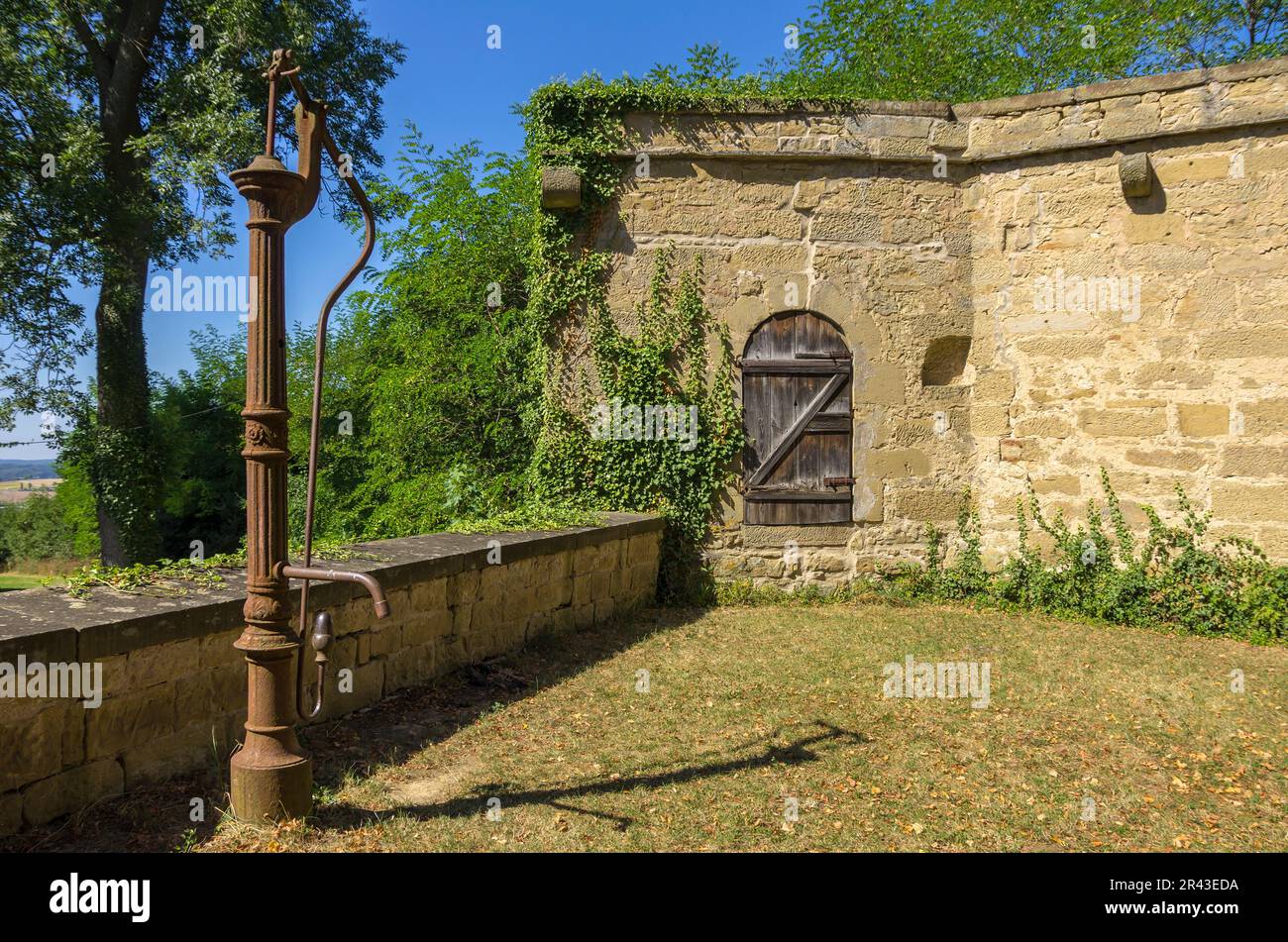 Castello di Ravensburg a Kraichgau vicino Sulzfeld, regione di Heilbronn, Baden-Württemberg, Germania, pompa d'acqua antiquata nel cortile esterno. Foto Stock