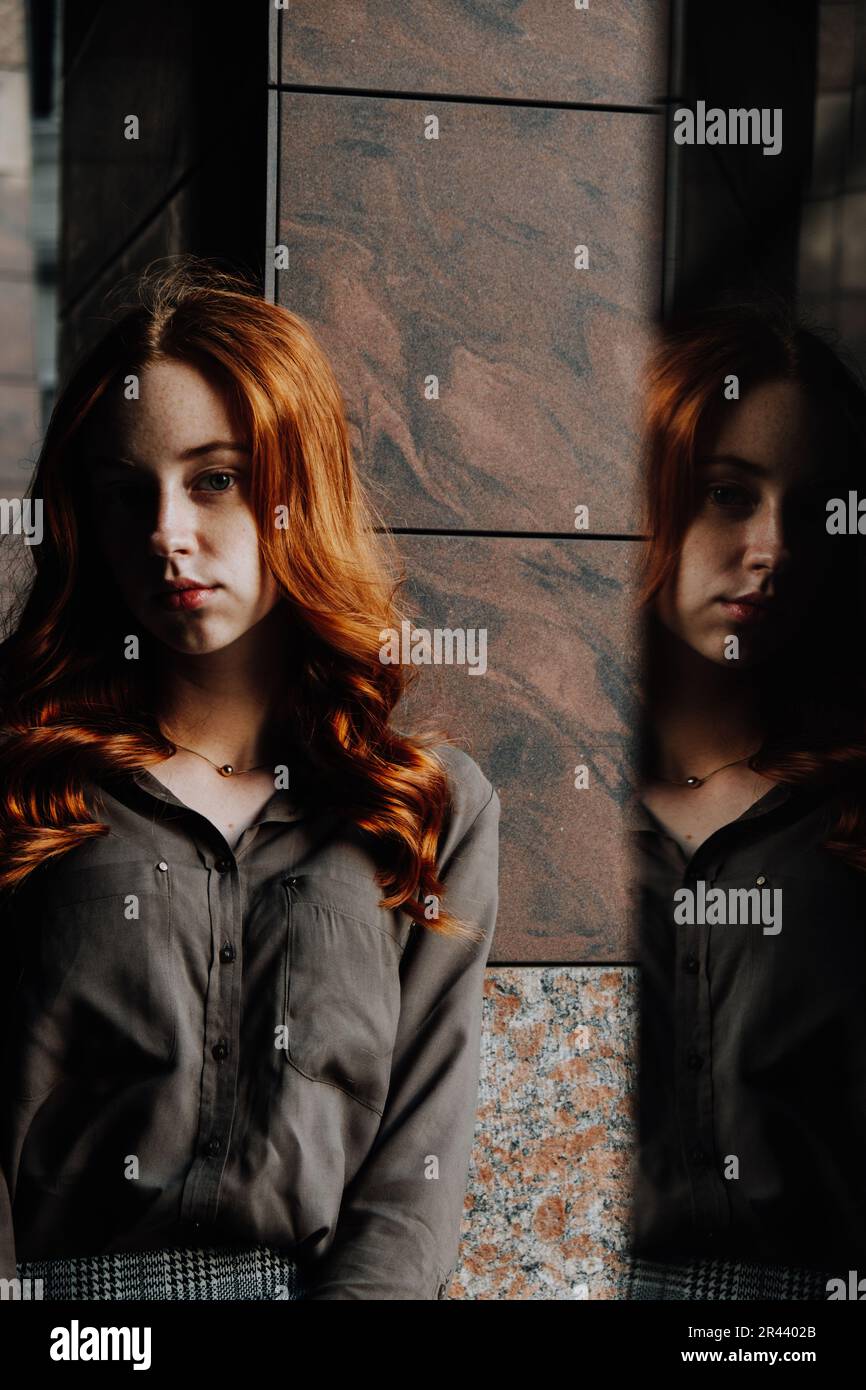 Ginger Girl con Freckles al tramonto vicino a Old Architecture Foto Stock