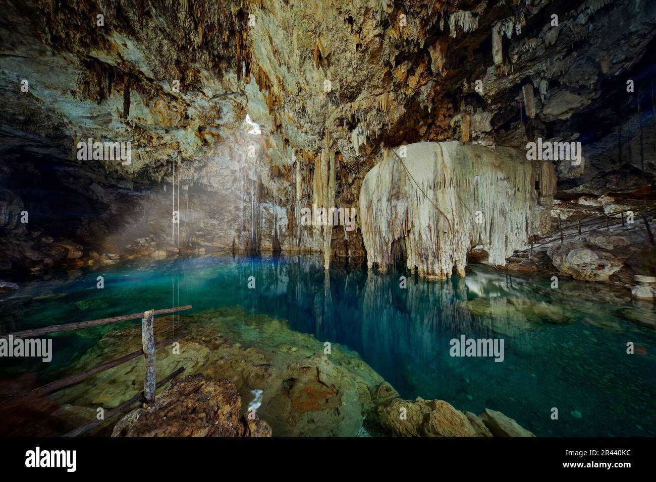 Cenote Dzitnup Xkeken, grotta a sud di Valladolid. Paesaggio a Yucatán, Messico. Verde acqua blu lago in grotta, luce nel buco. Viaggi in Messico. Foto Stock