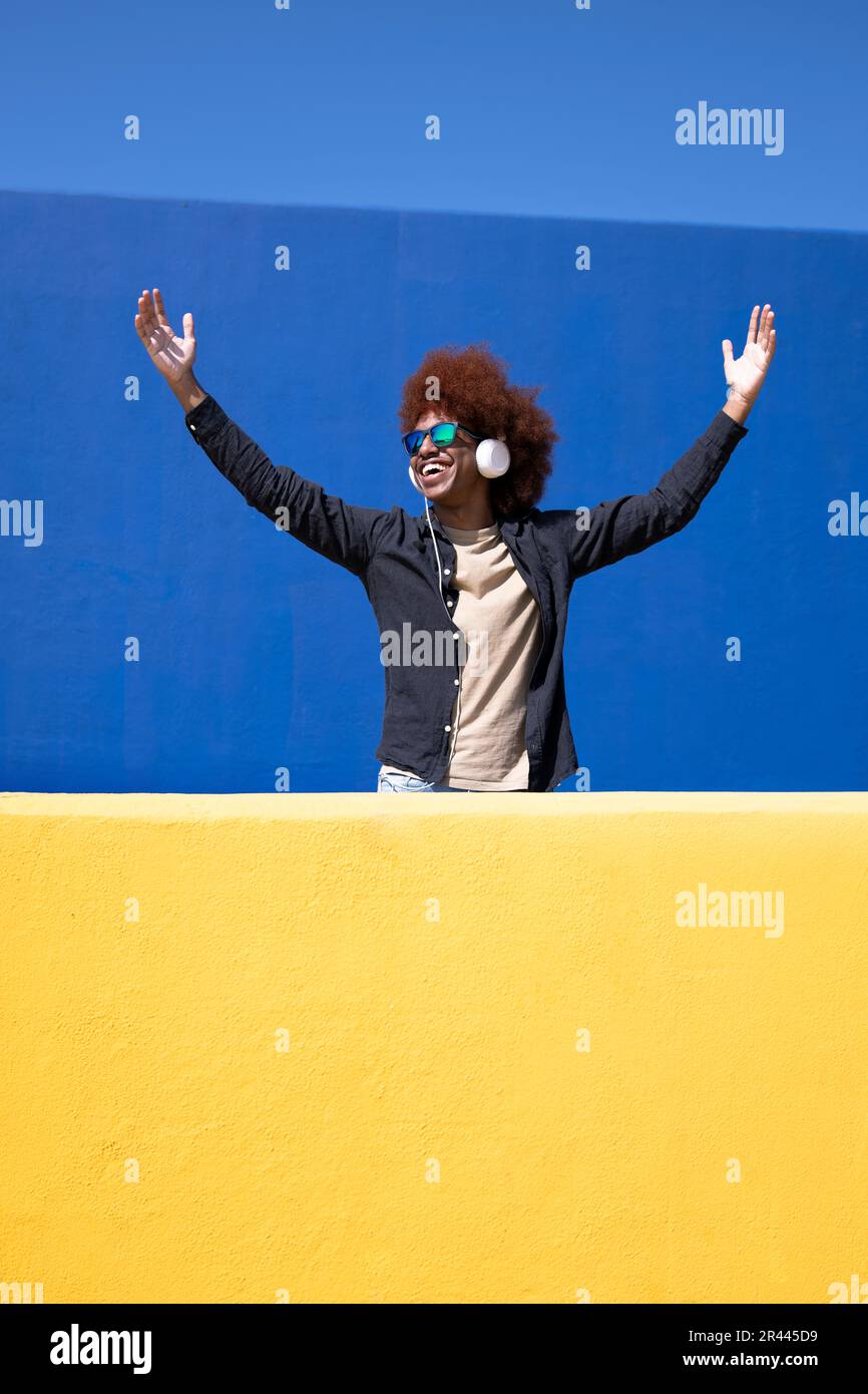 Ritratto di un giovane con capelli ricci e braccia distese Foto Stock