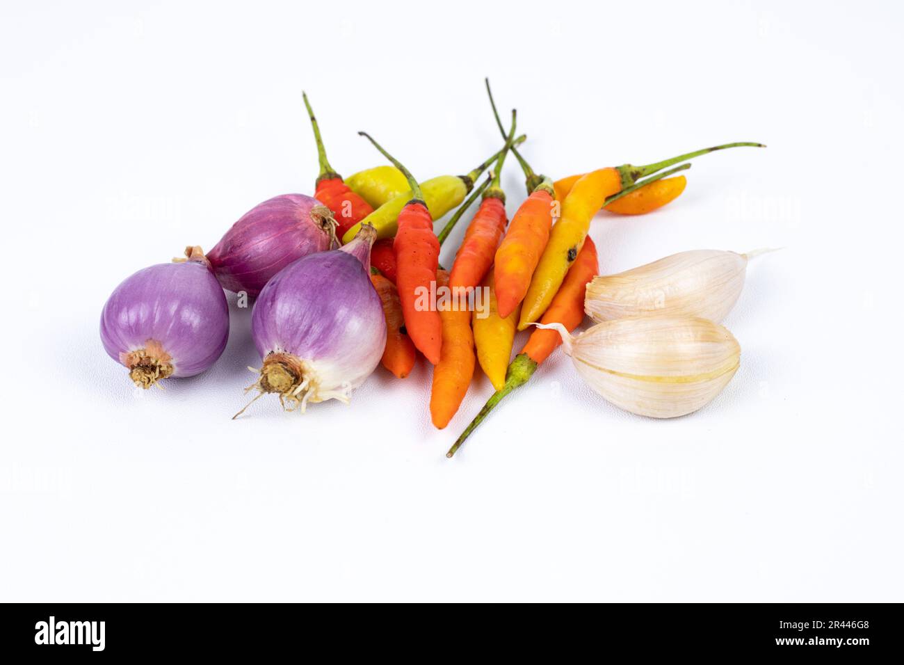 Condimenti: peperoncino, peperoncino riccio e cipolla rossa, scalogni isolati su fondo bianco Foto Stock