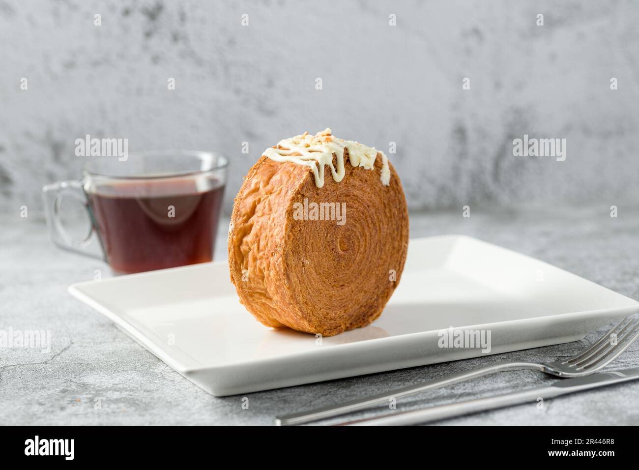 Rotolo di cioccolato New York o croissant rotondo con tè su tavolo di pietra Foto Stock