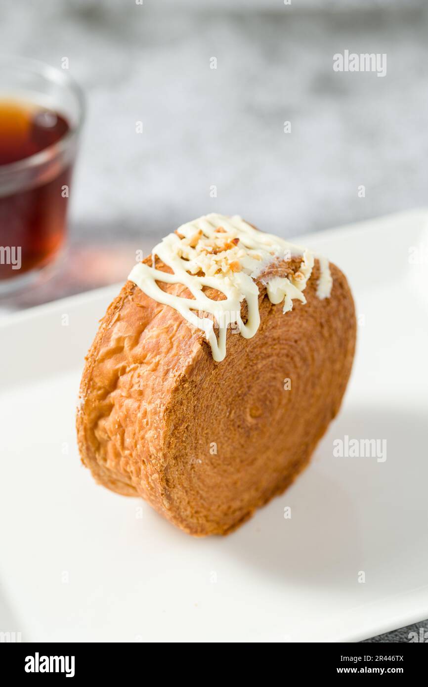 New York roll o croissant rotondo con marmellata con tè su tavolo di pietra Foto Stock