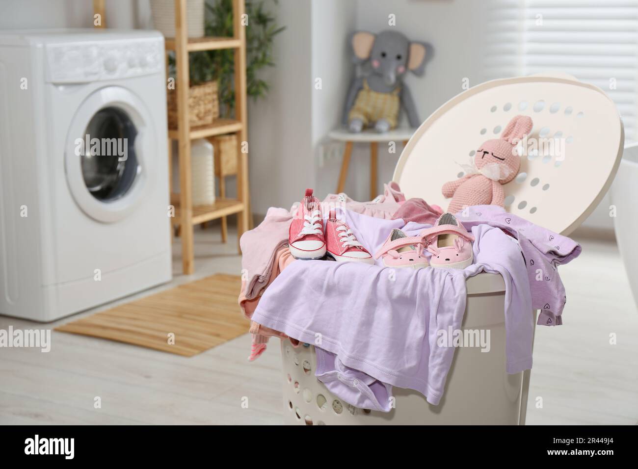 Cestino lavanderia con abiti per bambini, scarpe e uncinetto in bagno Foto  stock - Alamy