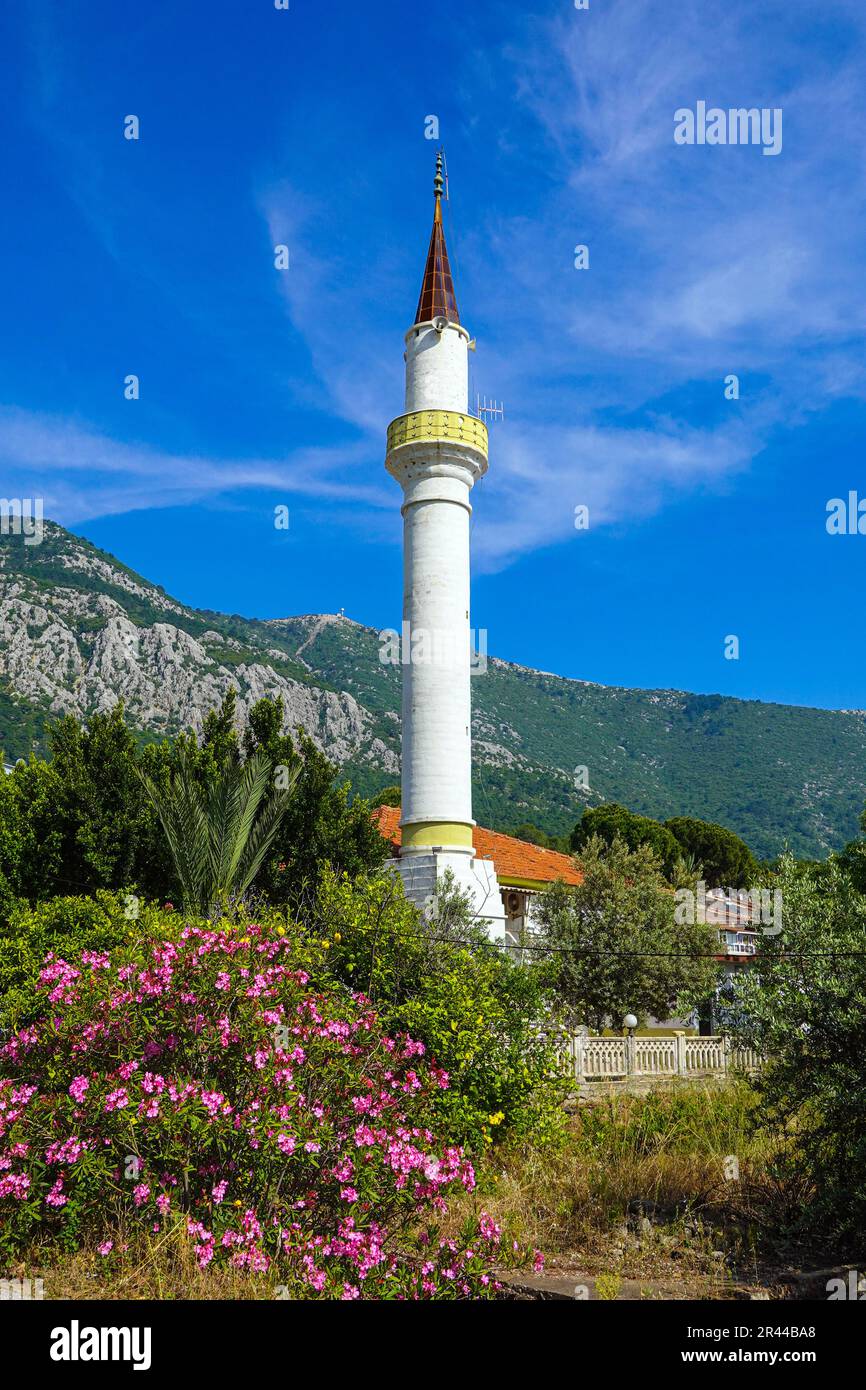 Minareto bianco una parte della moschea musulmana circondata da montagne, a Karaoz, Kumluca, Turchia Foto Stock