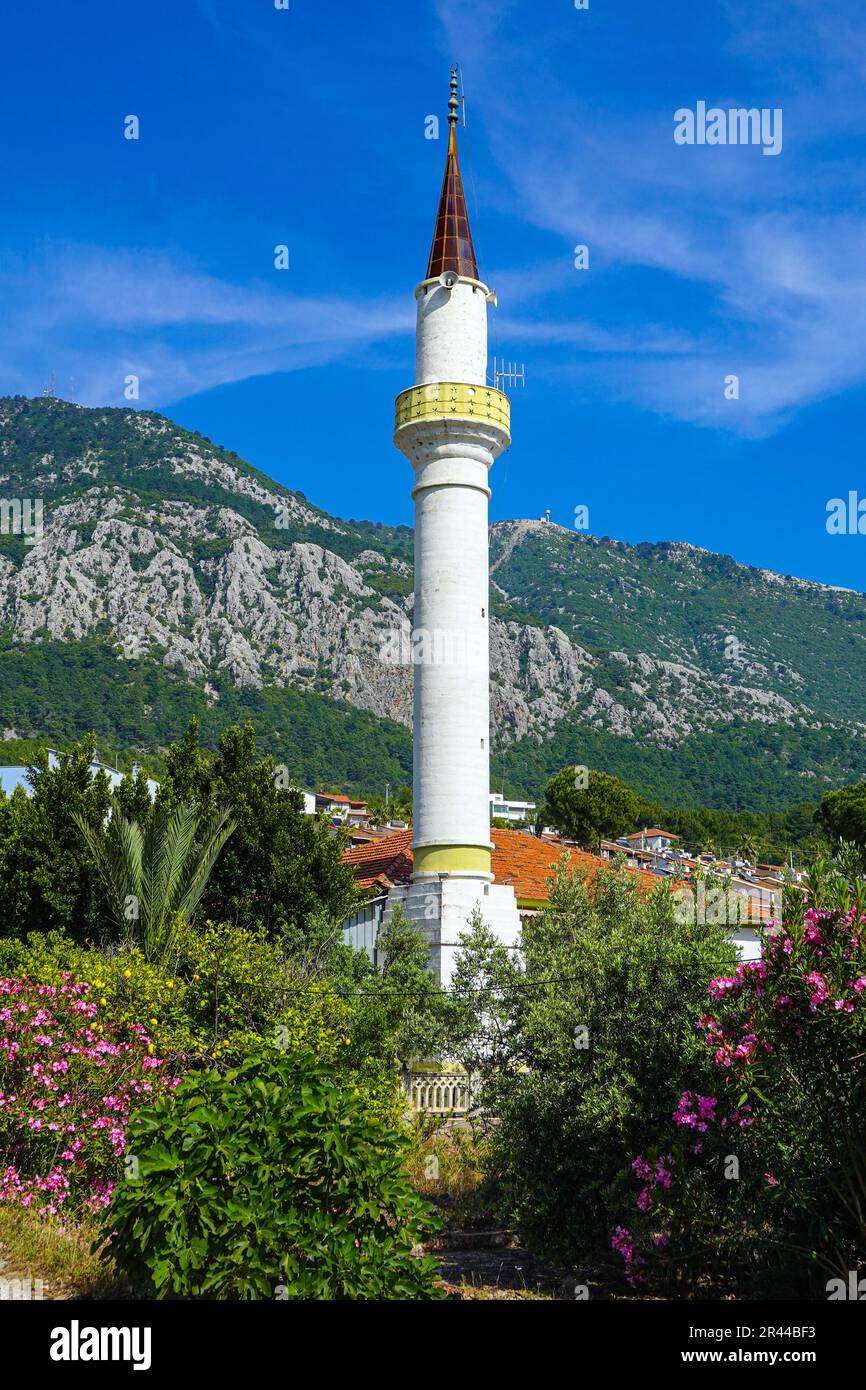 Minareto bianco una parte della moschea musulmana circondata da montagne, a Karaoz, Kumluca, Turchia Foto Stock