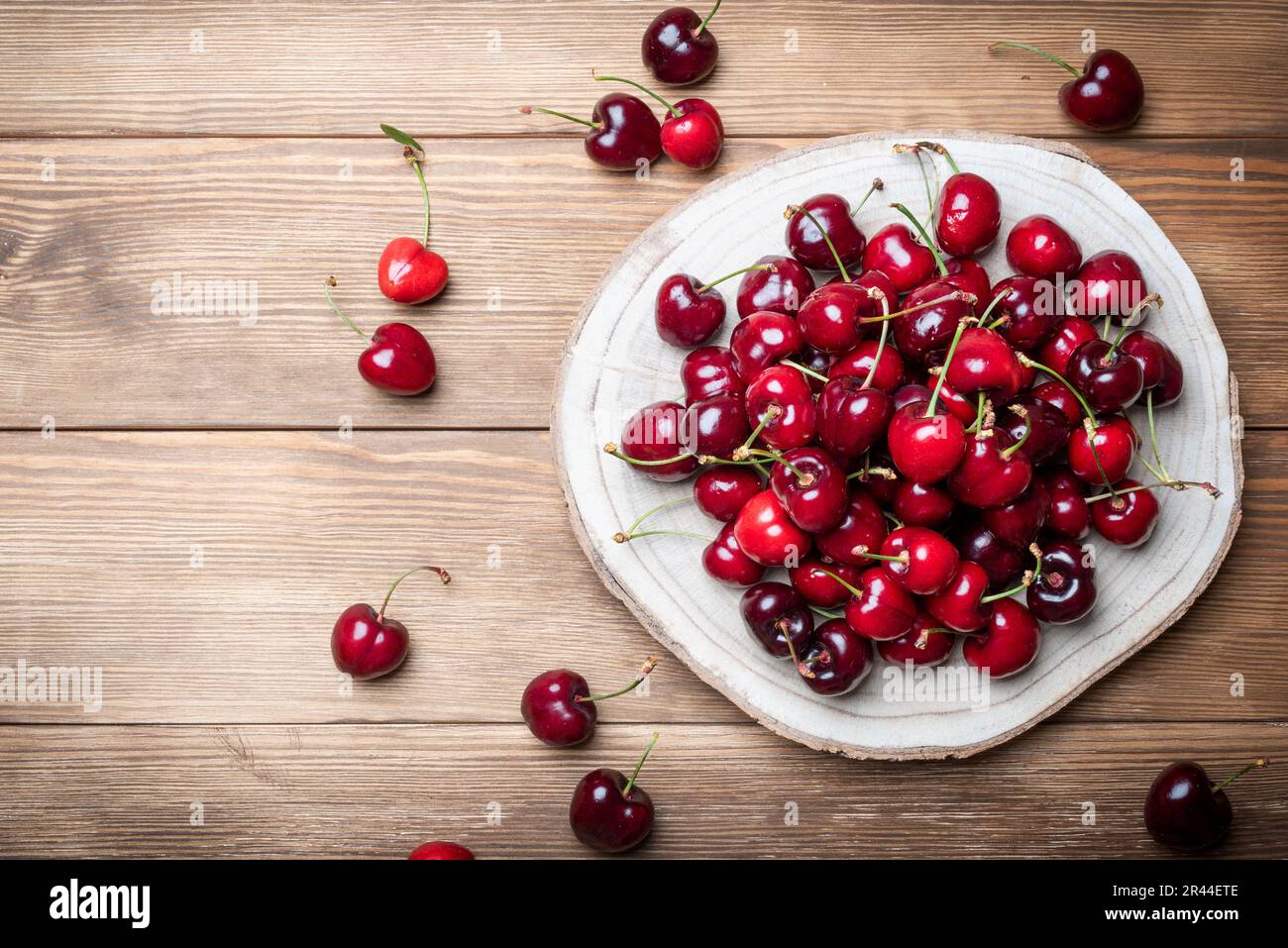 Set di ciliegie rosse ricche e sane su una base di legno. Frutti ricchi di vitamine per una dieta sana Foto Stock