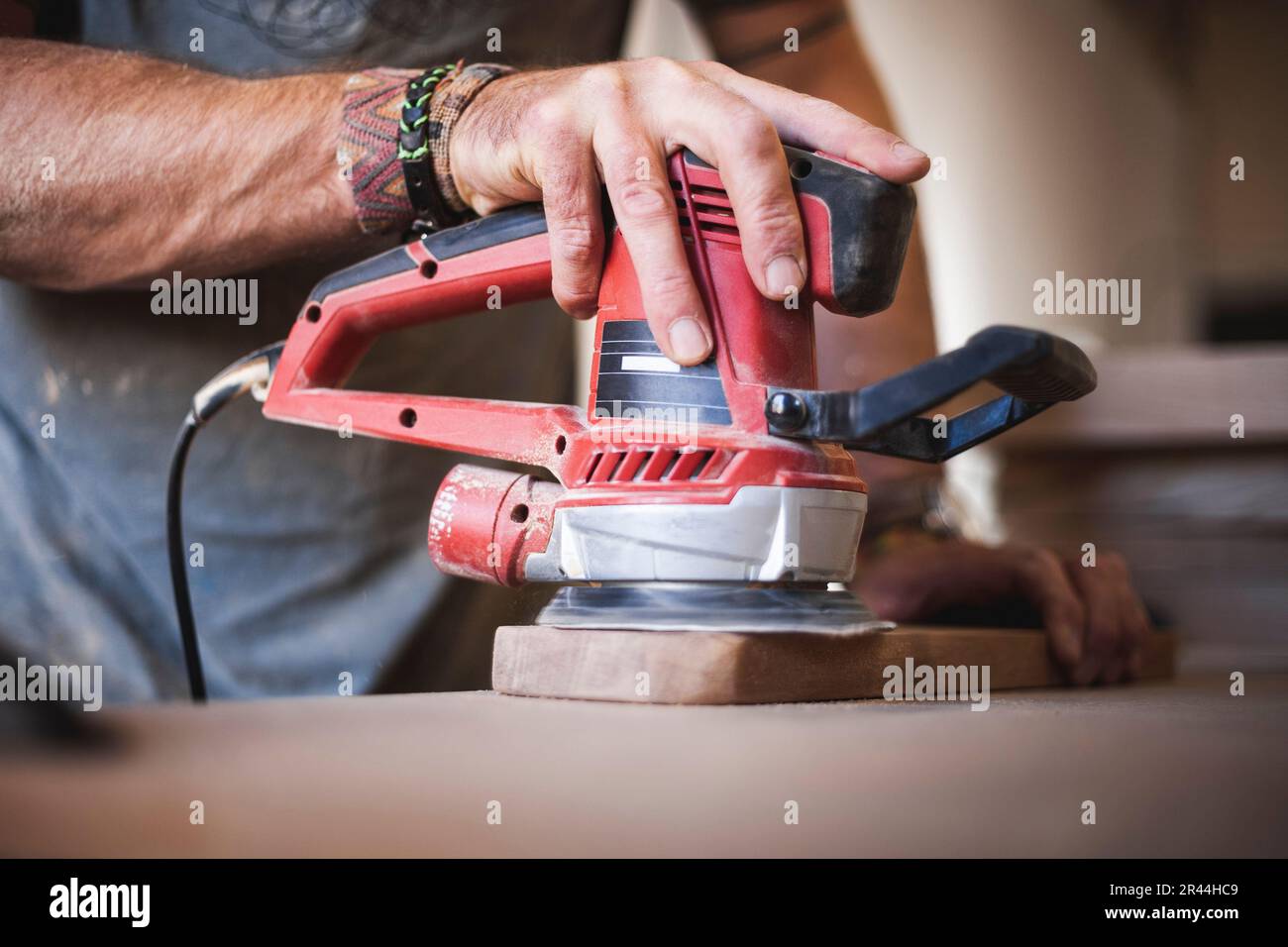 Scopri la maestria artigianale che si dispiega quando un abile artigiano impiega una levigatrice orbitale casuale per lucidare meticolosamente Foto Stock