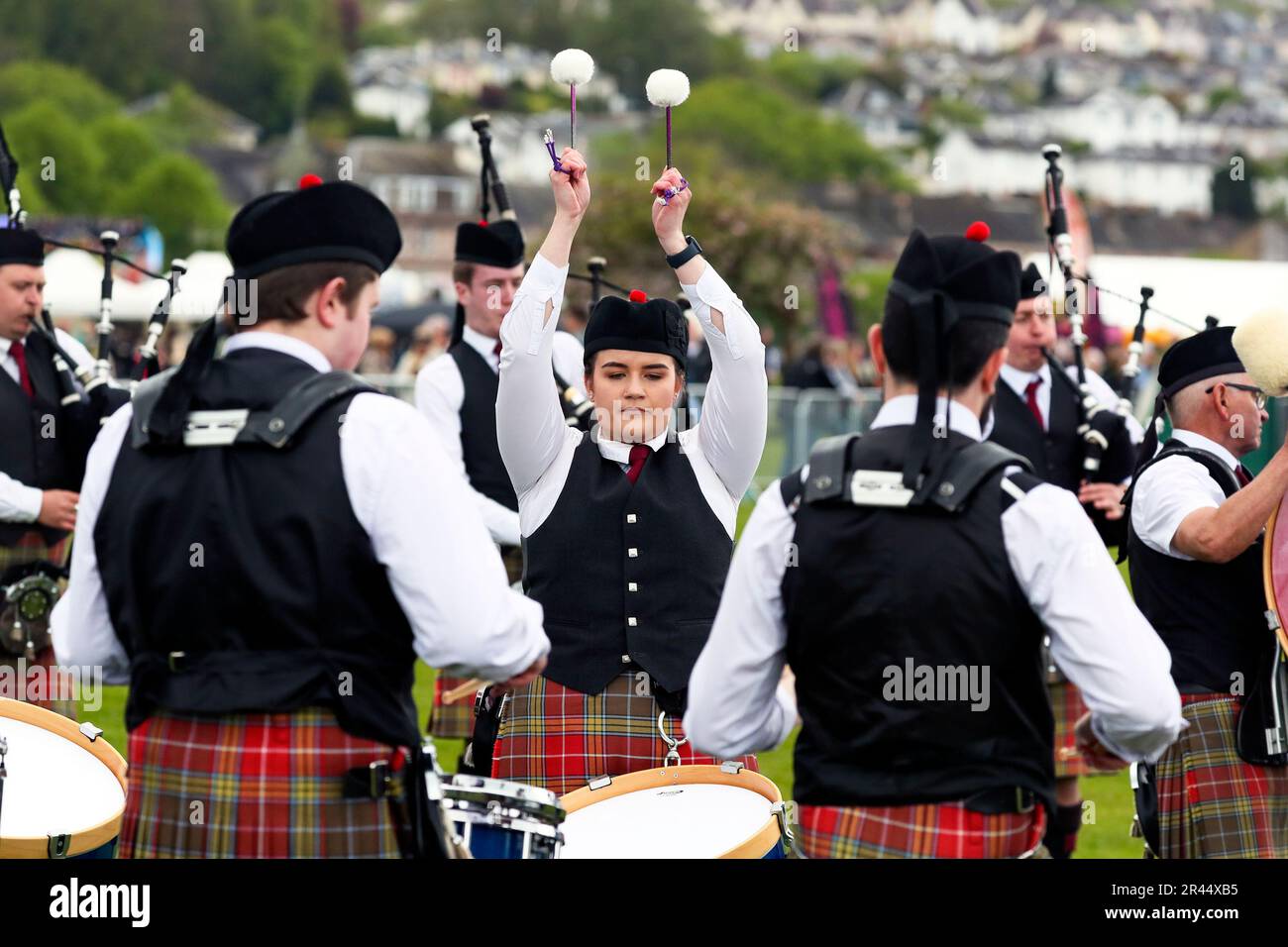 Batterista femminile che tiene il ritmo con la Milngavie Pipe Band mentre gioca a Gourock Highland Games, Inverclyde, Scozia, Regno Unito Foto Stock