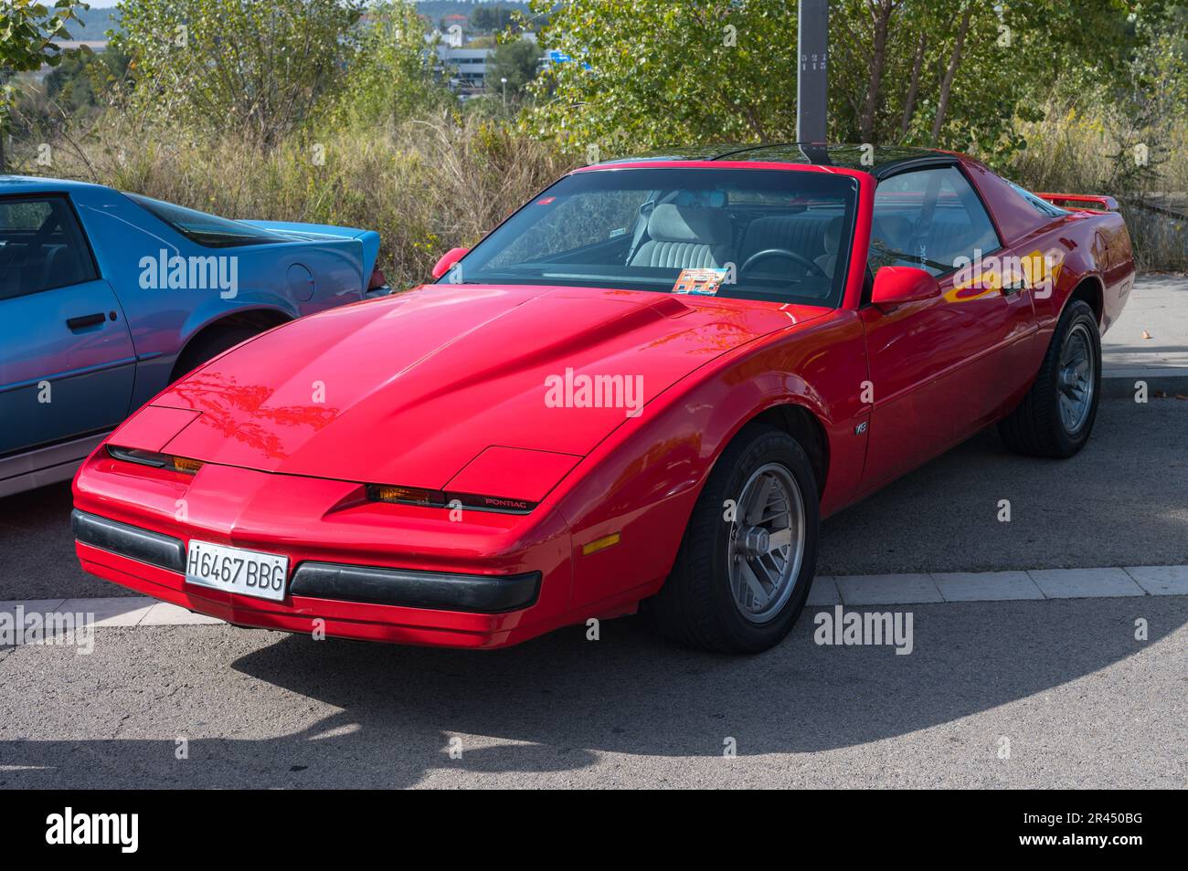 Vista frontale di una classica sportiva americana, terza generazione Pontiac Firebird di colore rosso parcheggiato in strada Foto Stock