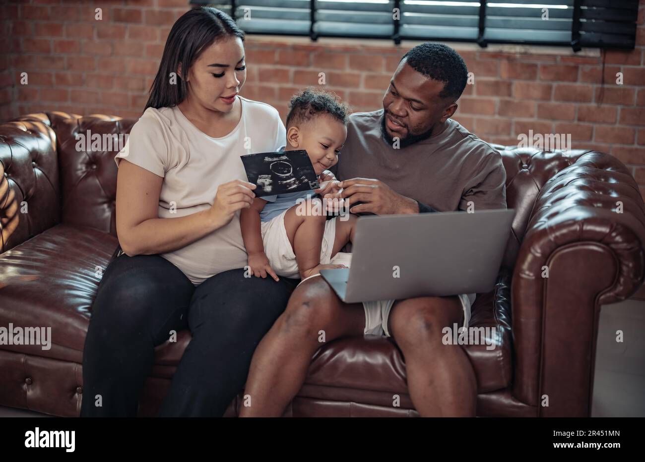 I membri della famiglia vedono le immagini ecografiche che mostrano il sesso, la salute, lo sviluppo del bambino nel grembo della madre e sono riempiti di gioia, di gioia e di eccitazione. Devozione Foto Stock