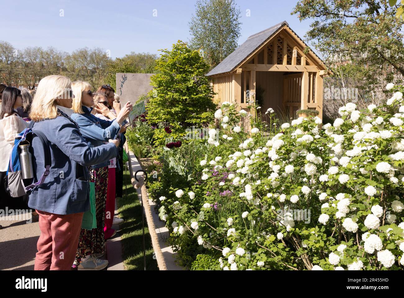 Chelsea Flower Show 2023 - visitatori che guardano i giardini dello spettacolo sotto il sole della primavera, evento sul calendario sociale britannico, Londra UK Foto Stock