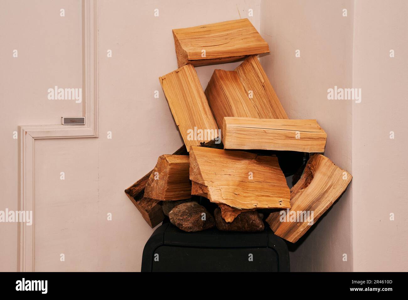 Un mucchio di legna da ardere tagliata impilata in un modello alternato, sulla cima di un vecchio stile televisore Foto Stock