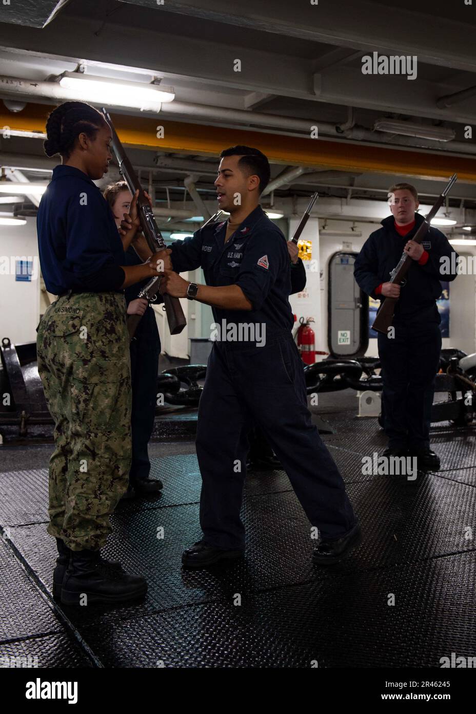 230118-N-TD381-1013 OCEANO PACIFICO (18 gennaio 2023) Aviazione Boatswain’s Mate (Equipment) 1st Classe Alberto Moreno, medio, nativo di Waukegan, Ill., istruisce Airman Jade Plaisimond, a sinistra, nativo di Hartford, Conn., durante una classe di guardia d’onore nel foc’isola del portaerei di classe Nimitz, USS Carl Vinson (CVN 70). Vinson sta attualmente conducendo operazioni marittime di routine. Foto Stock