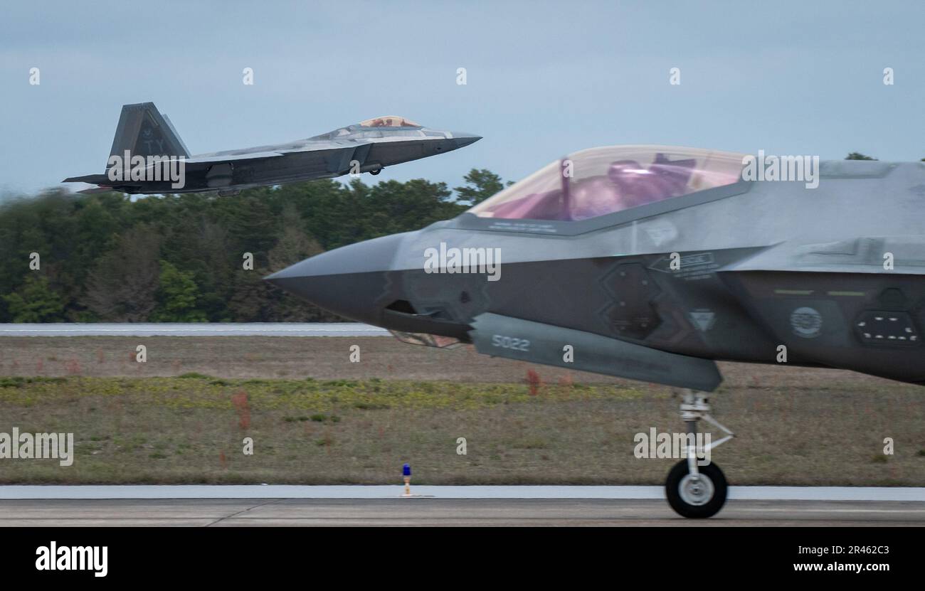 A 325th Fighter Wing F-22A Raptor vola da una 33rd Fighter Wing F-35A Lightning II Marzo 24 alla base dell'aeronautica militare di Eglin, Flah. Il velivolo Raptor del 325th FW si trova a Eglin dal 2018 dopo che l’uragano Michael ha distrutto le strutture della Tyndall AFB. I Raptors partiranno presto da Eglin per la loro nuova casa, Joint base Langley-Eustis, Virginia. Foto Stock