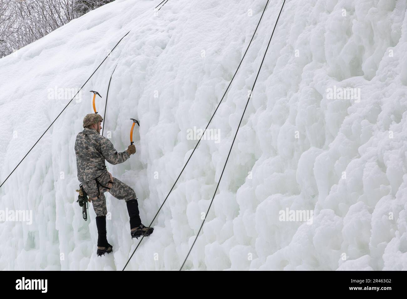 STATI UNITI Il ghiaccio del soldato dell'esercito sale durante l'addestramento di sostegno condotto dalla Alpha Company, 3rd battaglione, 172nd montagna di reggimento della fanteria), 86th squadra di combattimento della Brigata della fanteria (montagna), Guardia Nazionale dell'esercito del Vermont, all'Ethan Allen Firing Range, Jericho, Vt., 5 marzo 2023. L'attrezzatura speciale, come gli assi di arrampicata, l'imbracatura per sedersi, i moschettoni e i ramponi, consente ai soldati di affrontare terreni ripidi e ostacoli verticali altrimenti impraticabili. Foto Stock