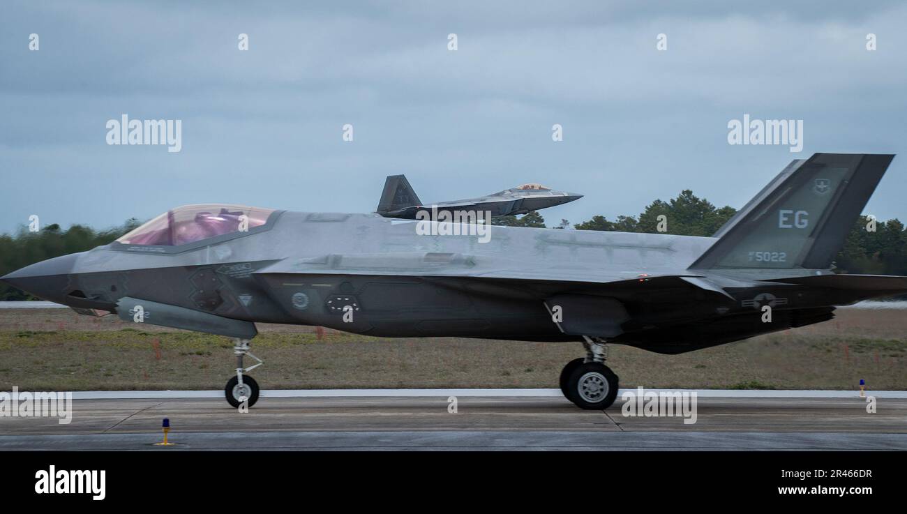 A 325th Fighter Wing F-22A Raptor vola da una 33rd Fighter Wing F-35A Lightning II Marzo 24 alla base dell'aeronautica militare di Eglin, Flah. Il velivolo Raptor del 325th FW si trova a Eglin dal 2018 dopo che l’uragano Michael ha distrutto le strutture della Tyndall AFB. I Raptors partiranno presto da Eglin per la loro nuova casa, Joint base Langley-Eustis, Virginia. Foto Stock