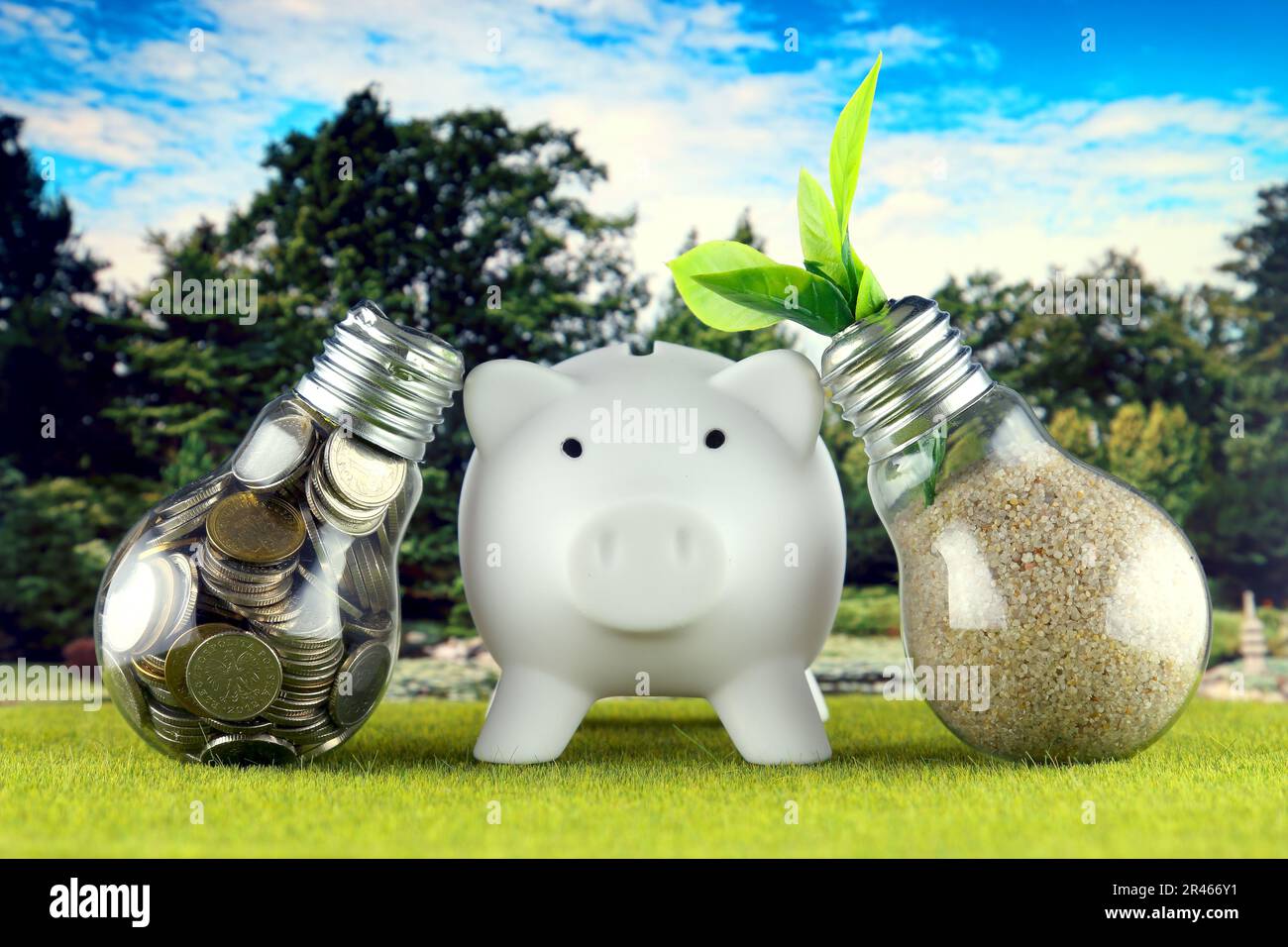 Monete all'interno della lampadina, pianta che cresce all'interno della lampadina e piggy bank. Eco-verde energia rinnovabile concetto. Prezzi dell'elettricità, risparmio energetico Foto Stock