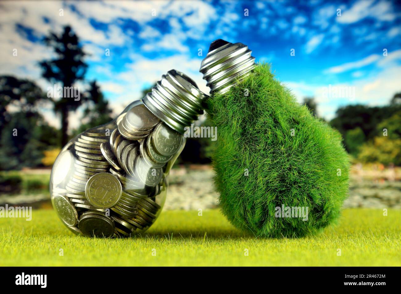 Monete all'interno della lampadina e lampadina verde eco con erba. Concetto di energia rinnovabile. I prezzi dell'elettricità, il risparmio energetico in famiglia. Foto Stock