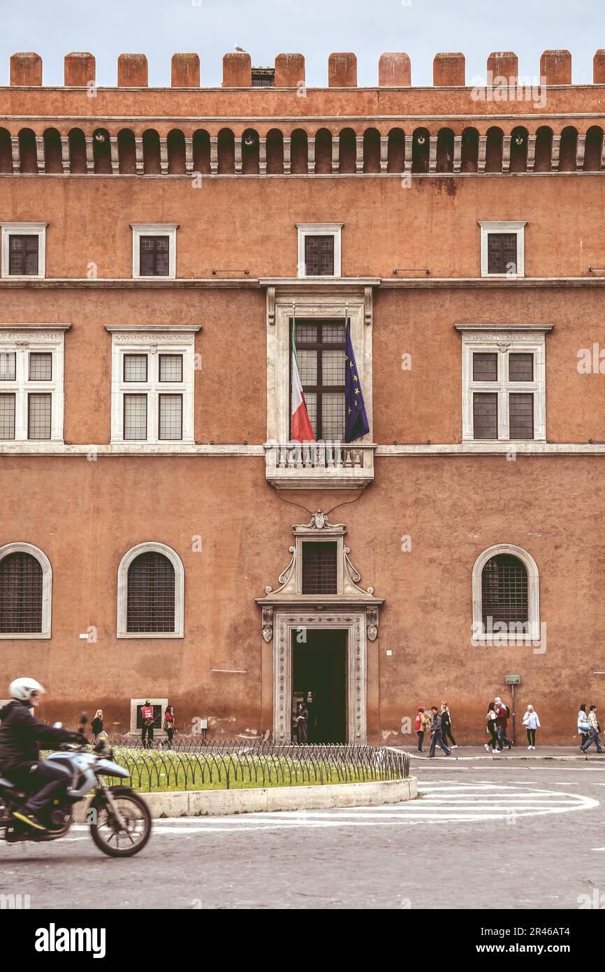 Una facciata del Palazzo di Venezia e il balcone di Mussolini con le bandiere italiane ed europee a Roma. Foto Stock