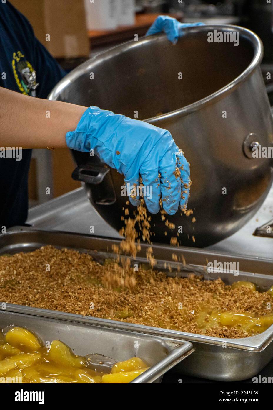 230410-N-EL850-1049 IONIAN SEA (10 aprile 2023) Specialista culinario 3rd Classe Ixshel Mendez, assegnato alla portaerei di classe Nimitz USS George H.W. Bush (CVN 77), aggiunge avena sul riempitivo per torte di mele, 10 aprile 2023. The George H.W. Bush Carrier Strike Group è in fase di implementazione pianificata negli Stati Uniti Naval Forces Europe area of Operations, impiegato dagli Stati Uniti Sesta flotta per difendere gli interessi degli Stati Uniti, alleati e partner. Foto Stock