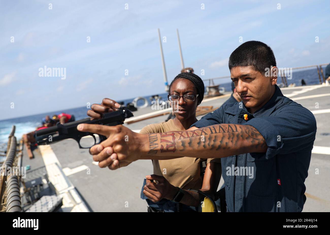 MARE DELLA CINA DEL SUD (27 marzo 2023) – Gunner’s Mate 3rd Classe Deshonda Williams (a sinistra), da Jacksonville, Florida, E Seaman Jesus Ramirez, da Houston, ispeziona una pistola da 9 mm durante l'addestramento per familiarizzare le armi a bordo del cacciatorpediniere missilistico guidato della classe Arleigh Burke USS Milius (DDG 69) mentre opera nel Mar Cinese Meridionale, marzo 27. Milius è assegnato al Comandante, Task Force 71/Destroyer Squadron (DESRON) 15, il più grande DESRON schierato in avanti della Marina e la principale forza di superficie della flotta degli Stati Uniti 7th. Foto Stock