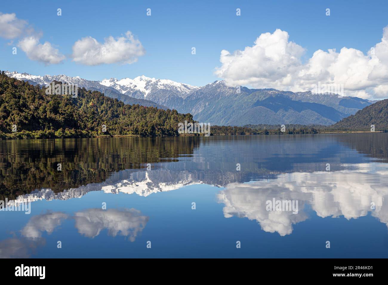 Idilliaco paesaggio del tranquillo Lago Mapourika che riflette le maestose montagne della Nuova Zelanda Foto Stock