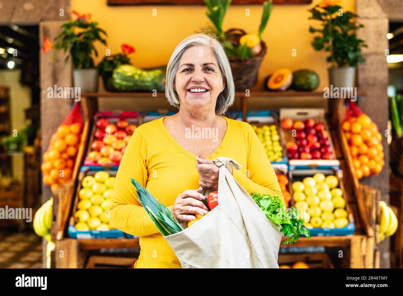 Donna anziana felice che compra frutta e verdura al mercato - concetto di cibo di shopping Foto Stock