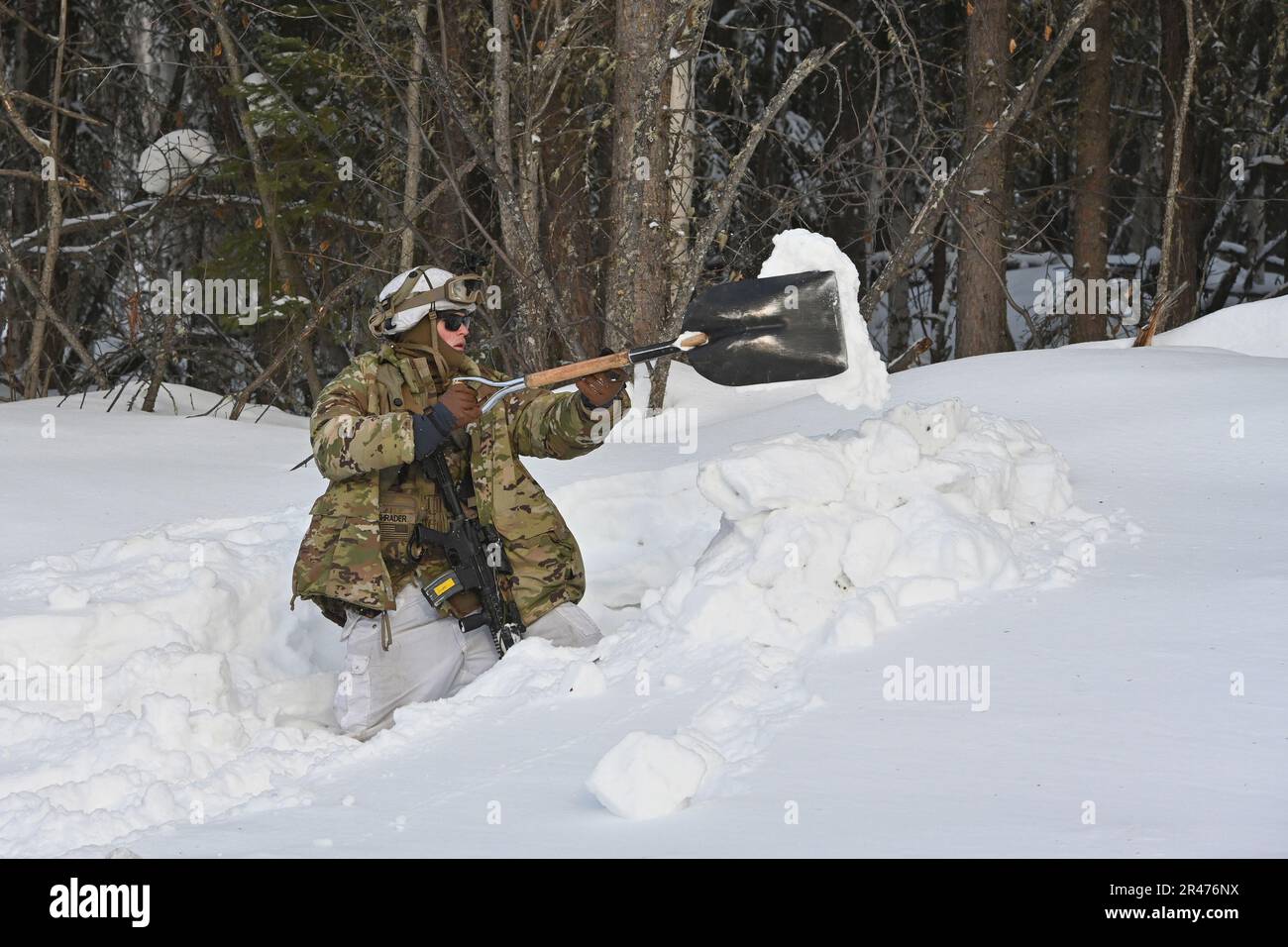 Joseph Shrader, 6th Brigade Engineer Battalion, 2nd Fanteria Brigata Combat Team (Airborne), 11th Airborne Division Digs a defensive fighting position in Deep Snow 2 aprile 2023, durante l'esercizio Joint Pacific multinazionale Readiness Center-Alaska 23-02 nella Yukon Training Area, Alaska. (Foto dell'esercito/John Pennell) Foto Stock