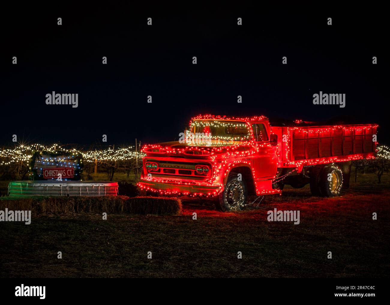 Un vecchio camion rosso illuminato con luci natalizie Foto Stock