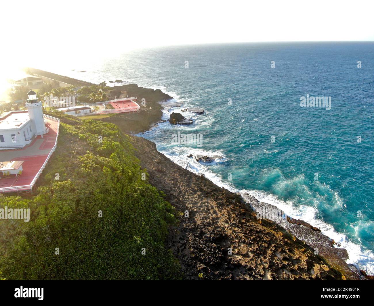 Un idilliaco scenario costiero caratterizzato da una pittoresca casa bianca situata vicino al litorale, con una spiaggia dorata Foto Stock