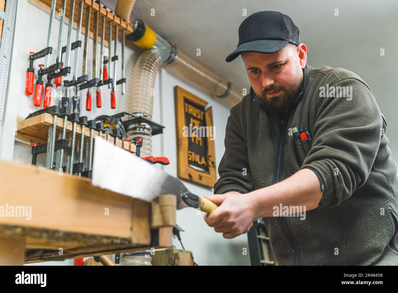 Le mani di un falegname che taglia un legno usando la sega giapponese nel suo negozio - Woodworking. Foto di alta qualità Foto Stock