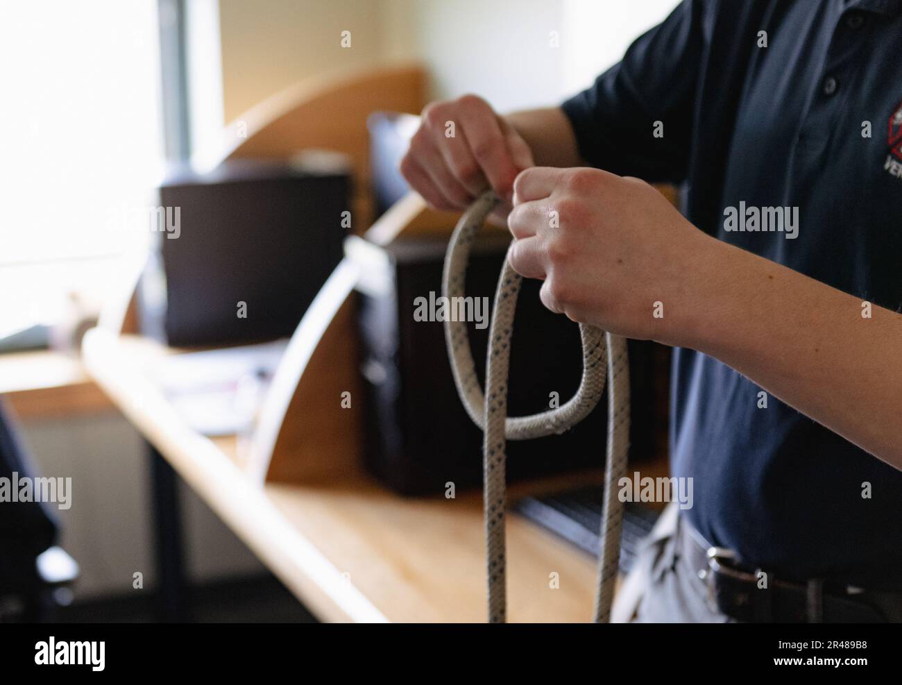 Uno studente di SkillsUSA dimostra le abilità di "knot-leging" durante una dimostrazione di abilità presso il Vermont Air National Guard Fire Department, South Burlington, VT, 6 aprile 2023. SkillsUSA è un'organizzazione nazionale che si concentra sulla formazione degli studenti delle scuole superiori per le carriere in mestieri qualificati, tra cui la lotta antincendio. Foto Stock