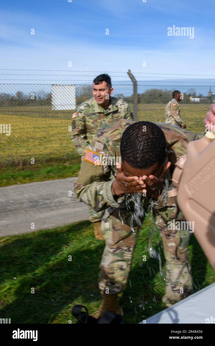 NEGLI STATI UNITI Soldier with 39th Strategic Signal Battalion si lava il viso dopo Mask Confidence Training, accanto al Training Support Center Benelux Chemical, Biological, Radiological and Nuclear room, sulla base aerea di Chièvres, 16 marzo 2023. Al fine di mantenere una buona conoscenza delle apparecchiature e delle procedure CBRN, l'unità ha condotto una formazione per garantire la disponibilità e soddisfare i requisiti annuali. Foto Stock