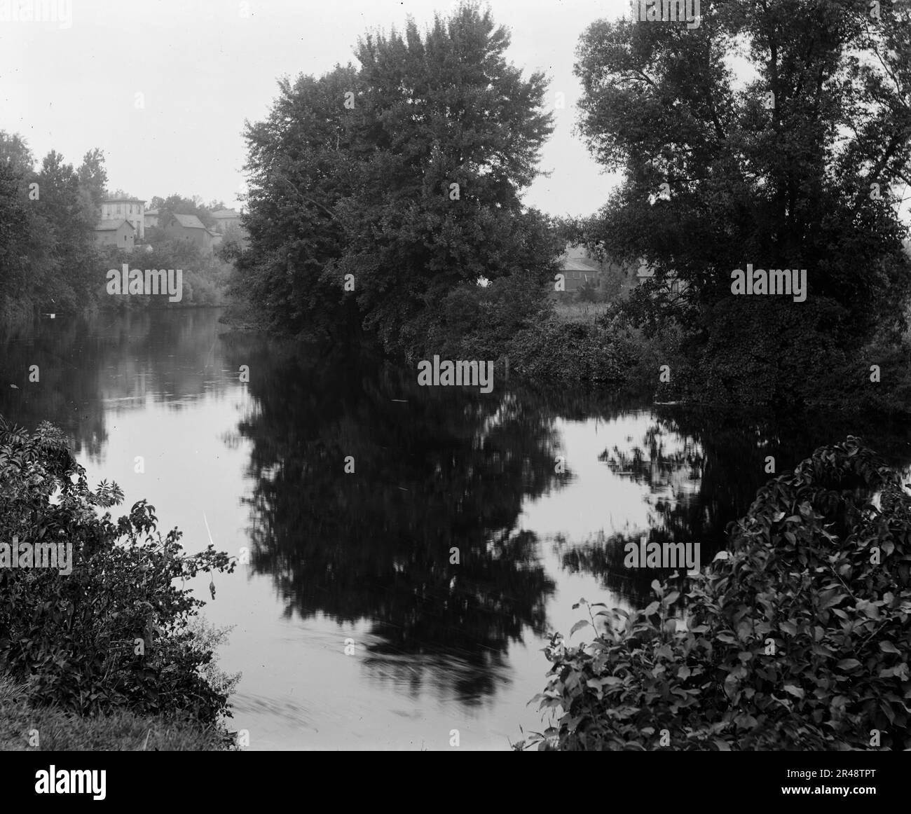 Fiume con edifici sullo sfondo, probabilmente il fiume Huron, Ypsilanti, Michigan, tra il 1900 e il 1910. Foto Stock