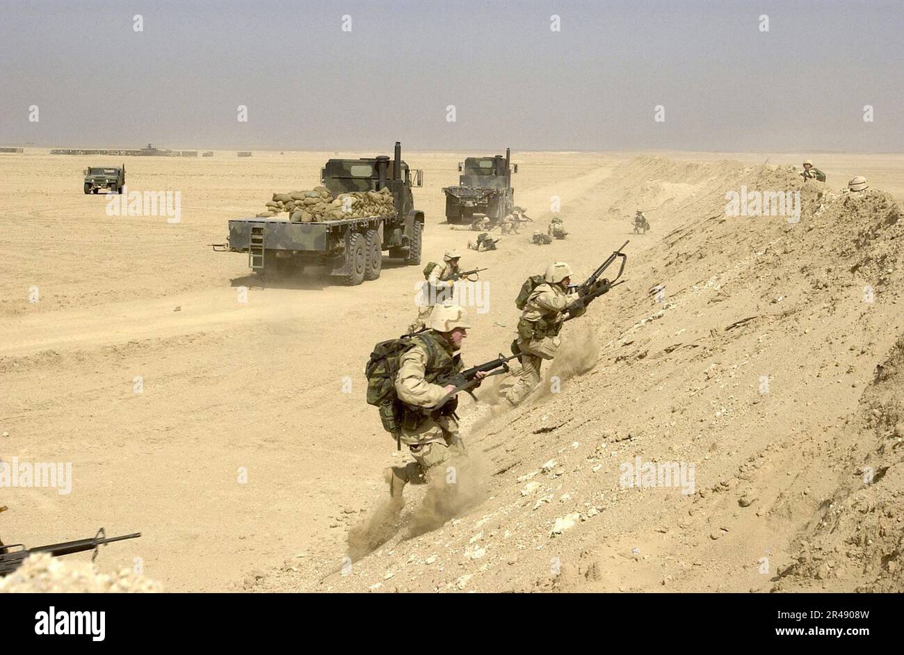 US Navy Seabees of Naval Mobile Construction Battaglione Settanta quattro (NMCB-74) precipita su un berme di sabbia dopo aver preso fuoco da forze opposte simulate Foto Stock
