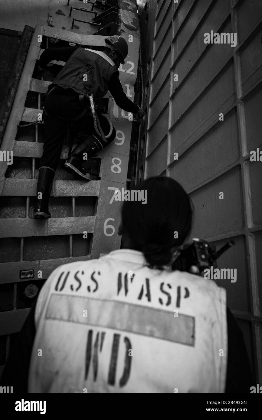 230328-N-CE729-1178 OCEANO ATLANTICO (28 marzo 2023) Boatswain’s Mate 1st Class Khadijah Faison, a destra, osserva Aircrew Survivalman Airman Jadeon Wells che si prepara ad abbassare il cancello di poppa a bordo della nave d'assalto anfibia USS Wasp (LHD 1) per condurre test di zavorra, 22 marzo 2023. WASP sta conducendo prove in mare con Type Commander (TYCOM). Foto Stock