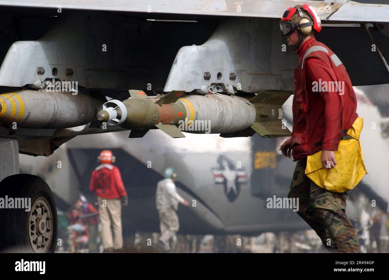 US Navy un ordigno di aviazione tira il perno di sicurezza da una bomba laser GBU-12 500 lbs guidata su un F-A-18 Hornet Foto Stock