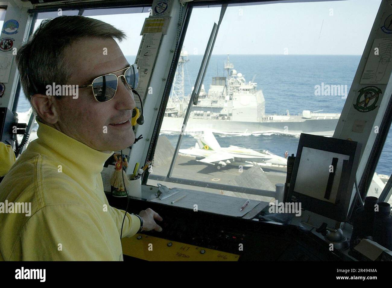 US Navy l'Air Boss osserva le operazioni di volo dal controllo primario del ponte di volo come un combattente di attacco F-A-18C assegnato al Foto Stock