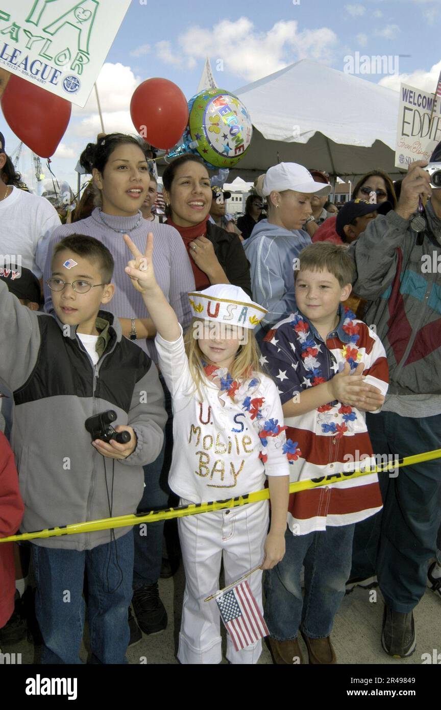 I membri e gli amici della US Navy Family si acclamano mentre la USS Mobile Bay (CG 53) attracca alla Naval Station di San Diego Foto Stock