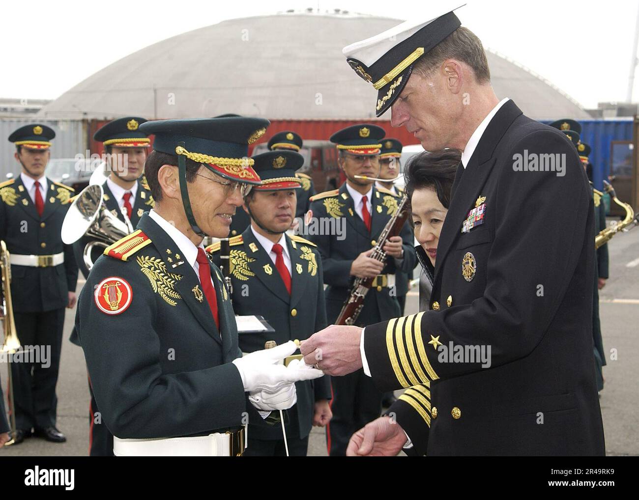 US Navy Commanding Officer, della nave di comando e controllo USS Blue Ridge (LCC 19), dà il bandleader della giapponese Maritime Self Defense Force (JMSDF) Band a Blue Ridge challe. Foto Stock