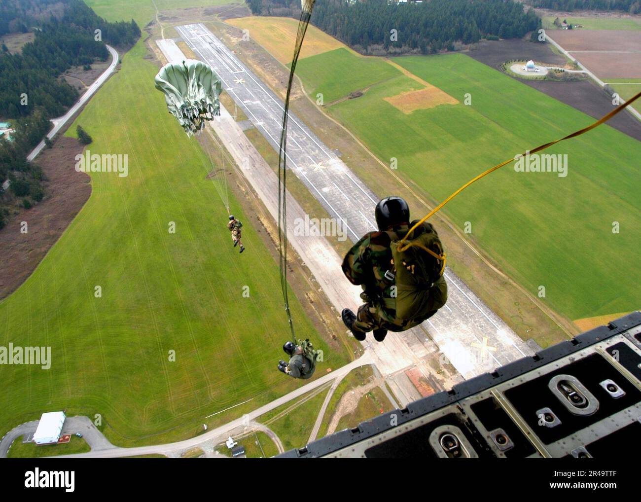 US Navy Explosive Ordnance Disposal Mobile Unit Eleven (EODMU-11) membri eseguono un salto statico dalla rampa di un C-130 Hercules, in gruppi di tre Foto Stock