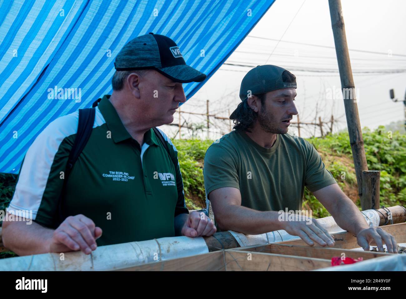 Da destra, Justin Pyle, Difesa POW / mia Accounting Agency (DPAA) esperto di recupero scientifico, mostra il Sig. Timothy Borland, Veterans of Foreign Wars (VFW) Comandante in Capo, oggetti trovati durante lo scavo, durante una visita da DPAA e Veterans of Foreign Wars (VFW) leadership, Nghệ An Province, Repubblica socialista del Vietnam, 29 marzo 2023. Durante la visita, Borland ha visto in prima persona gli sforzi di recupero per i militari statunitensi persi durante la guerra del Vietnam, ha discusso con i membri del team di recupero e ha partecipato a un pranzo con l'Ufficio vietnamita per la ricerca della leadership delle persone scomparse. Foto Stock