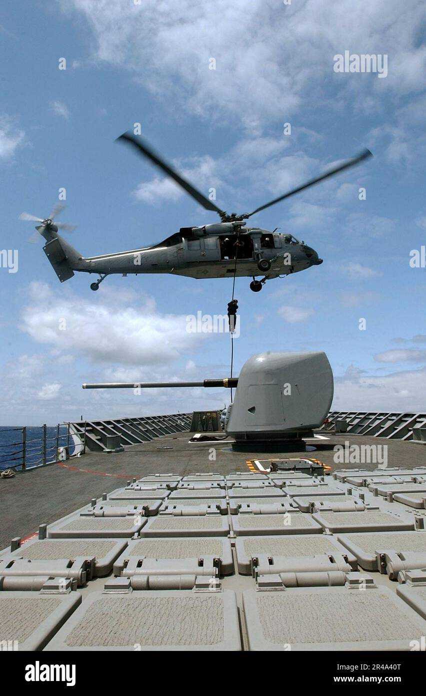 US Navy Un Sailor assegnato a disposizione esplosiva Ordnance Mobile Unit Eleven (EODMU-11), fast-ropes da un MH-60s Knighthawk Foto Stock