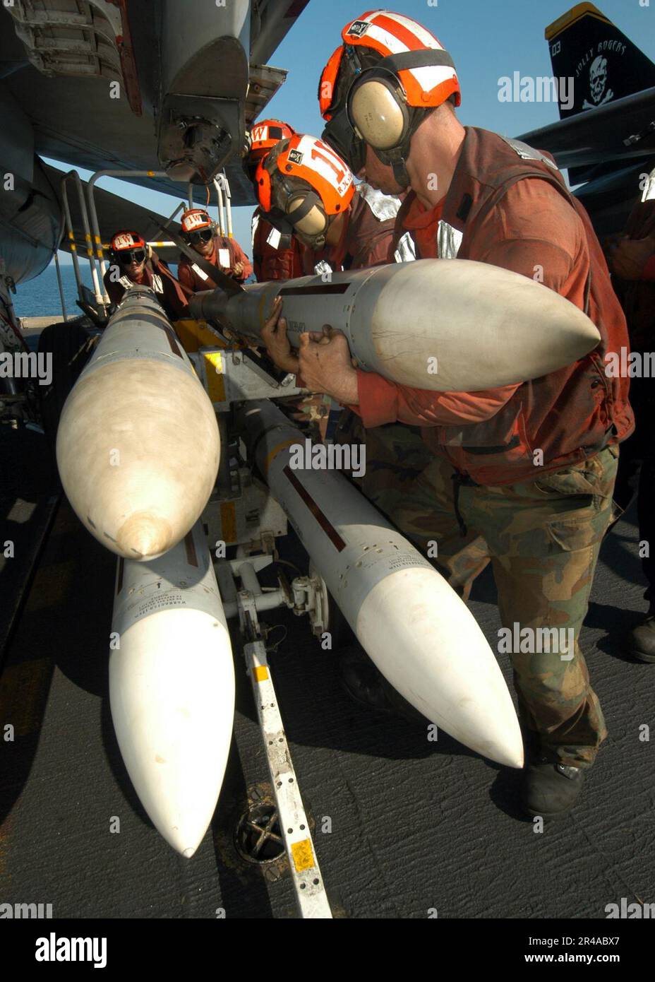 US Navy Aviation Ordnancemen, assegnato al Jolly Rogers of Fighter Squadron One Zero Three (VF-103), carica I missili aria-aria GUIDATI RADAR sparrow AIM-7 su un F-14B Tomcat Foto Stock